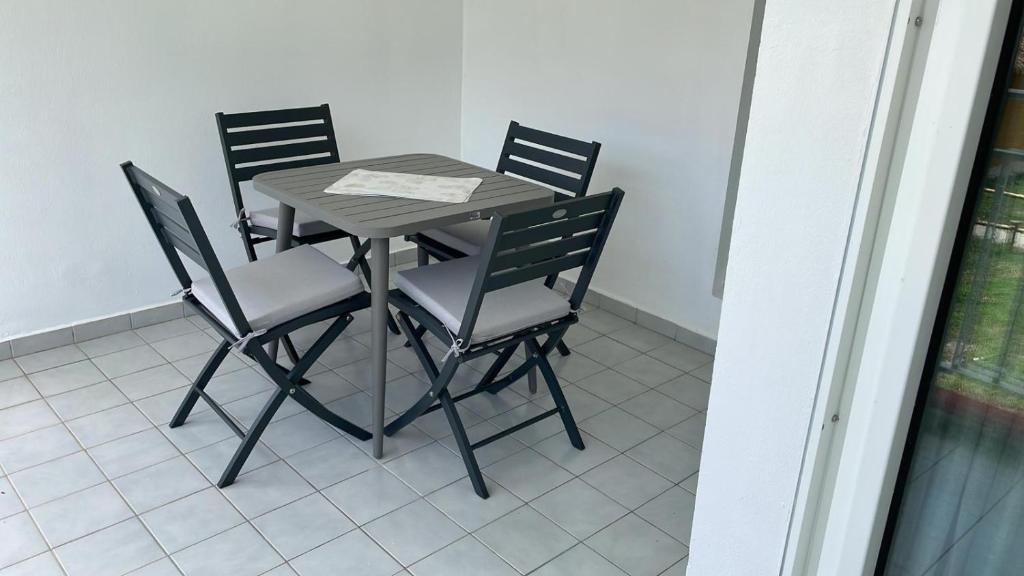 a dining room table and four chairs in a room at Village Kawann - Toumalacai 246 in Grand-Bourg