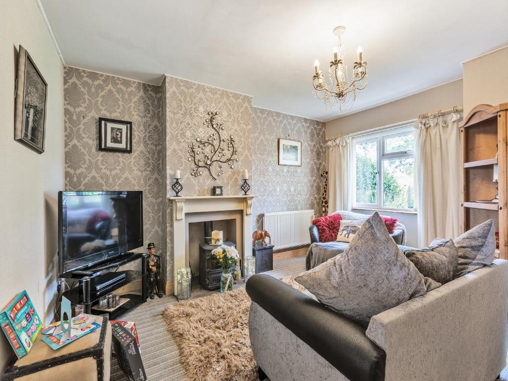 a living room with a couch and a television at Flyby Cottage in Symonds Yat