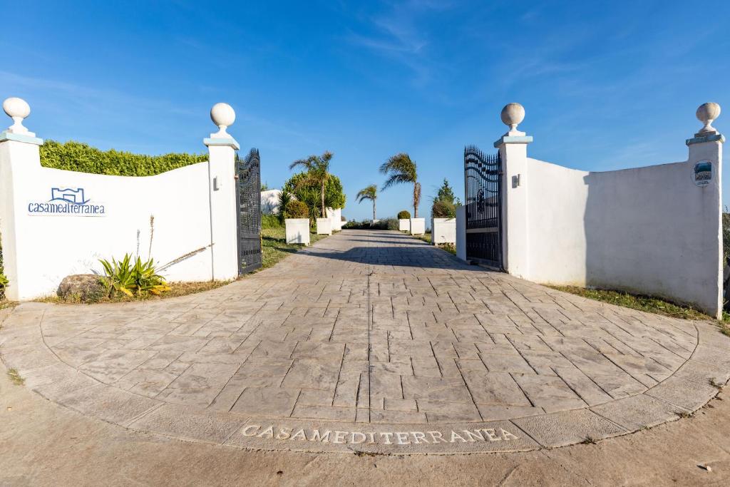 a driveway leading to a white fence with a gate at Casamediterranea in Sperlonga