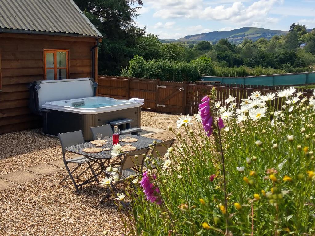 a backyard with a table and a hot tub at Seven Stars- hot tub & garden with fabulous views. in Llandrindod Wells