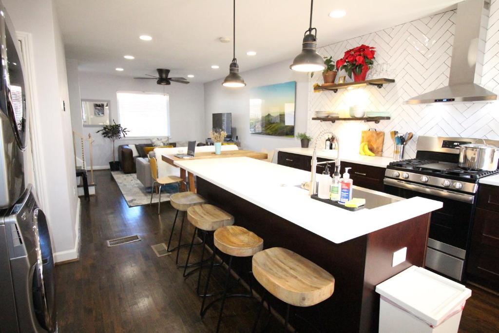 a kitchen with a large white counter and stools in it at Capitol Hill Adjacent Home Steps to Park and River in Washington
