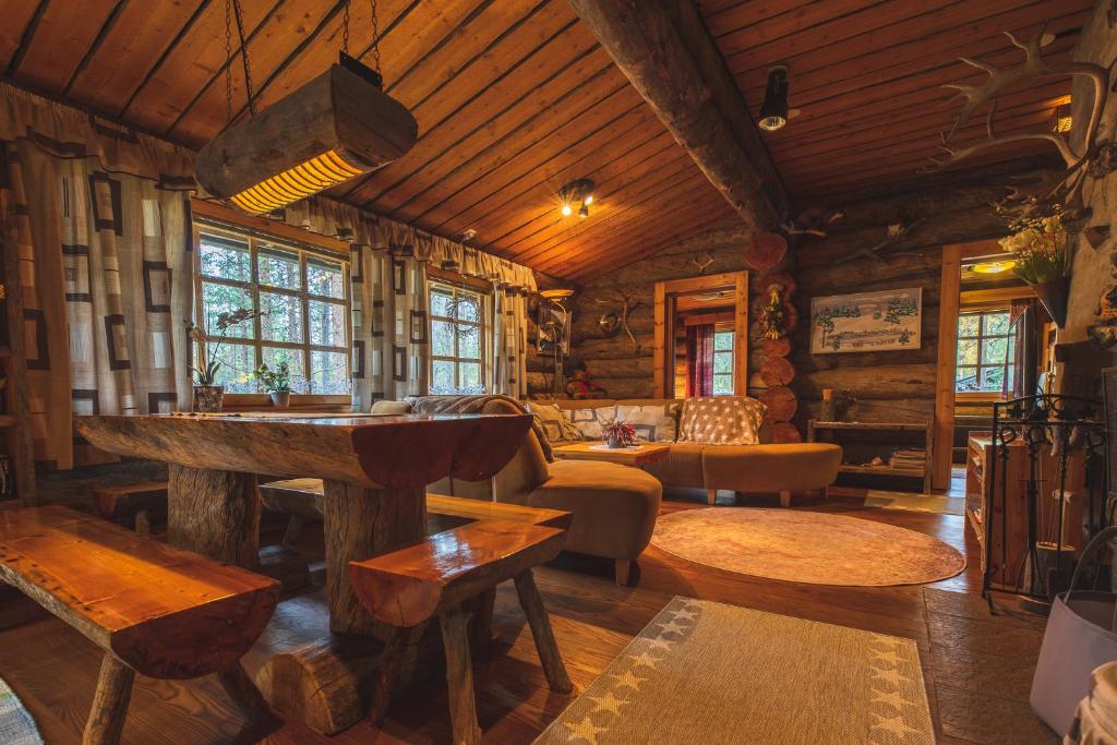 a living room in a log cabin with a table and chairs at Hellevi by Aavalevi in Levi