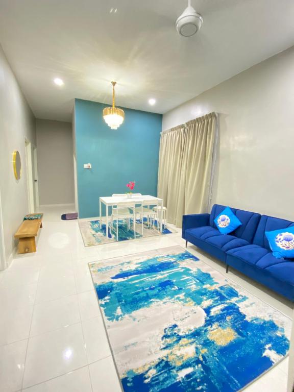un soggiorno con divano blu e tavolo di HZ HOMESTAY PENDANG a Pendang