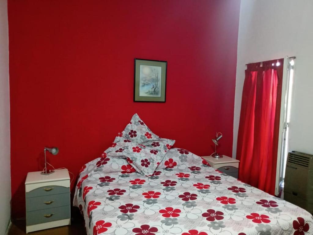 - une chambre rouge avec un lit avec un mur rouge dans l'établissement Canela House, à Huerta Grande