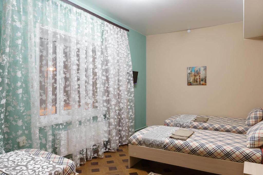 ZarechnyyにあるHotel Veronaのベッドルーム1室(ベッド2台、カーテン付)
