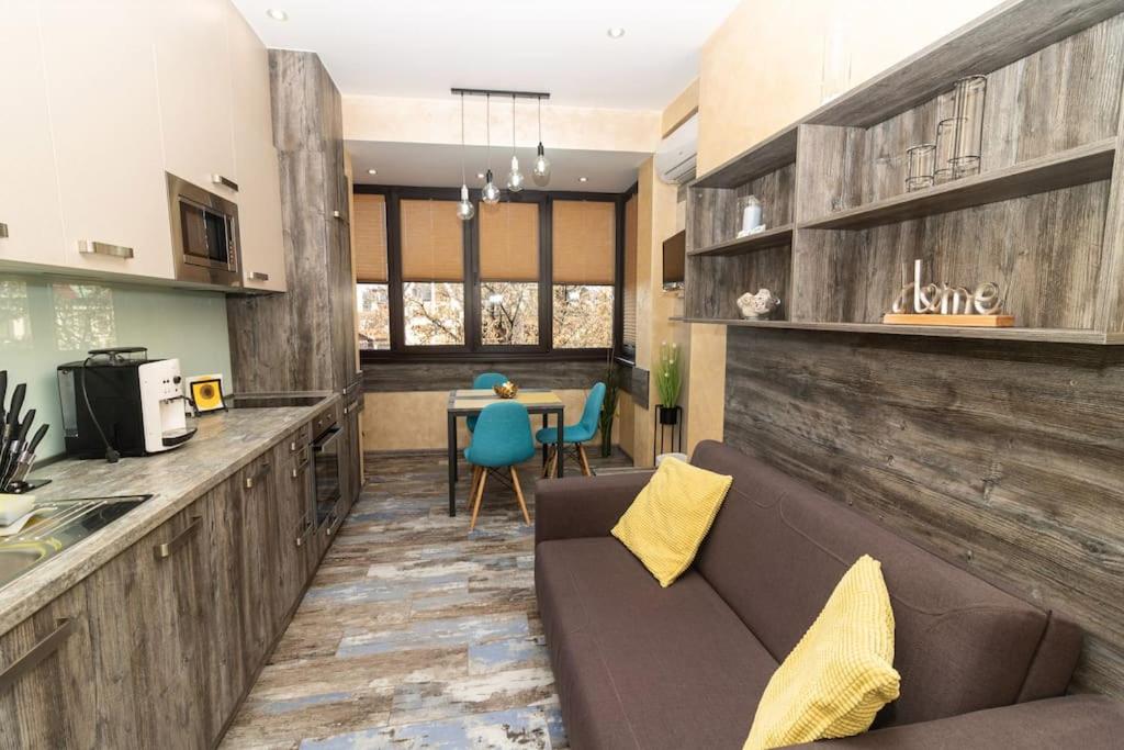 a kitchen and living room with a couch and a table at Unique Central 1 Bedroom Flat in Sofia