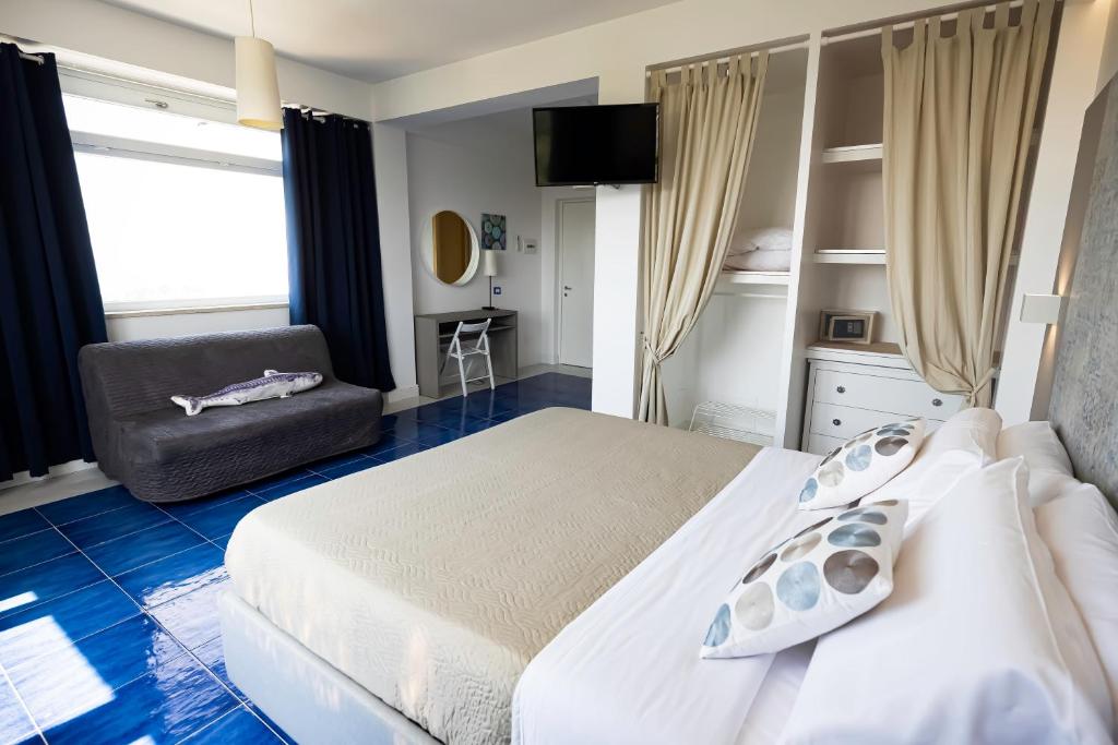 a bedroom with a white bed and a chair at Casamediterranea in Sperlonga