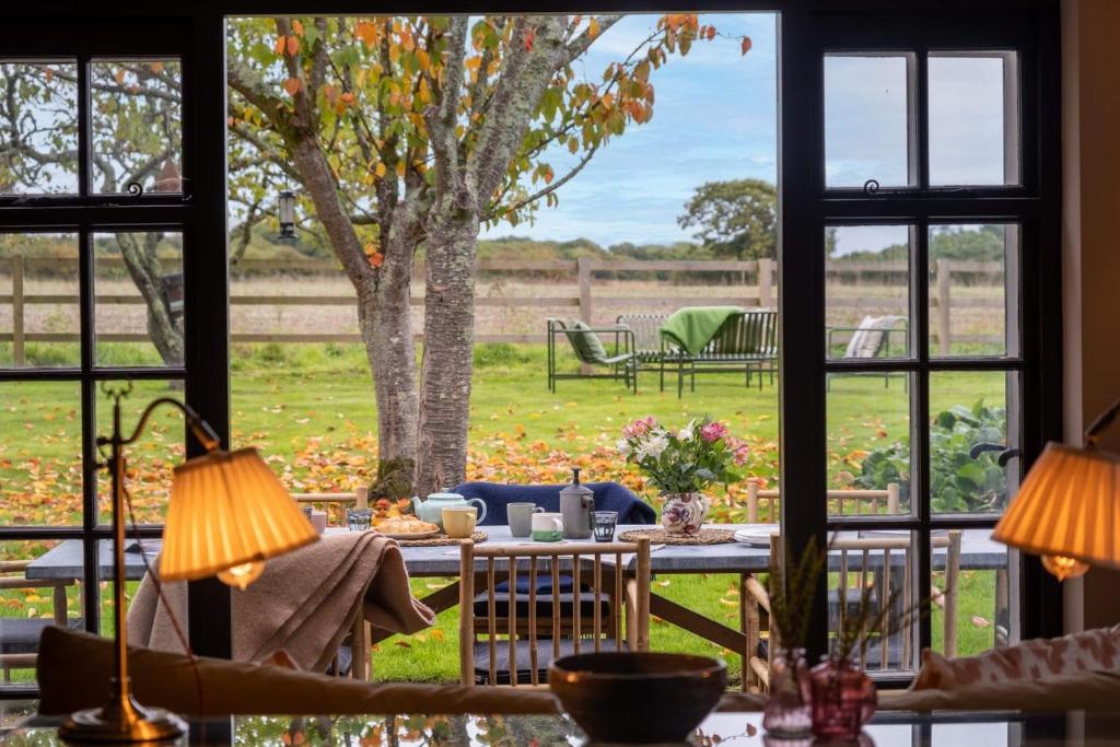 a room with a table and a view of a yard at Pond House in Lymington