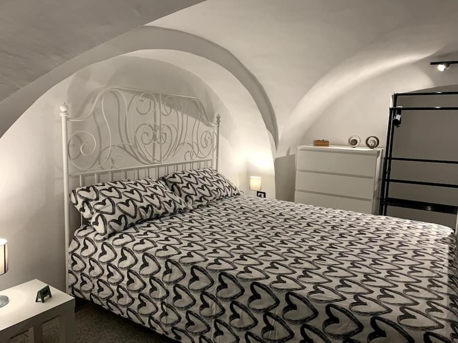 una camera da letto con un grande letto con copriletto bianco e nero di Buatta house a Catania