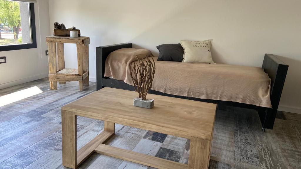 a bedroom with a bed and a wooden table at Moderno depto frente al río! in San Nicolás de los Arroyos