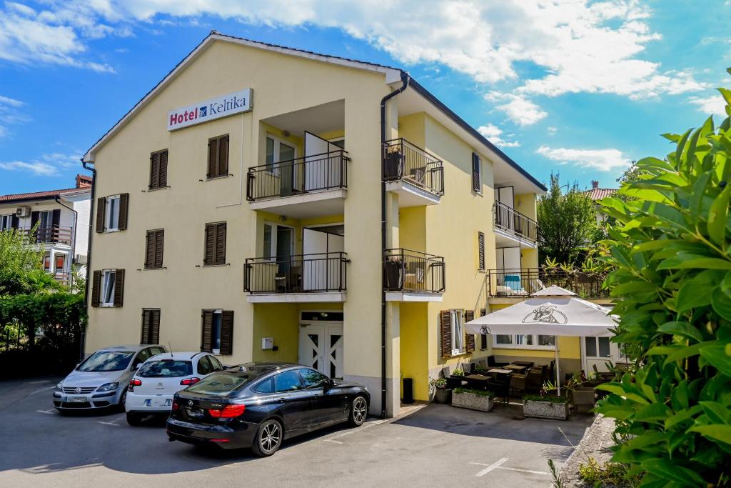 um edifício com carros estacionados em frente em Hotel Keltika em Izola