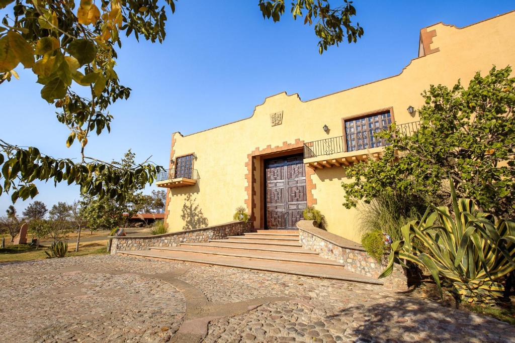 una casa amarilla con escaleras que conducen a una puerta en Hacienda Maria Eugenio, en Guanajuato