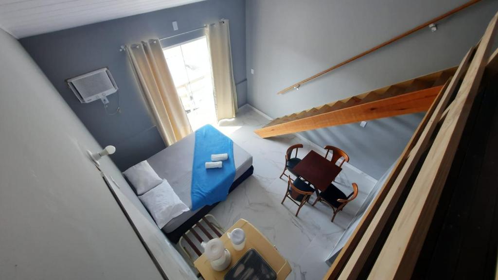 an overhead view of a room with a bed and a chair at CK - APTO TIPO LOFT Individual ar, wifi, vaga, cozinha- in Itapema