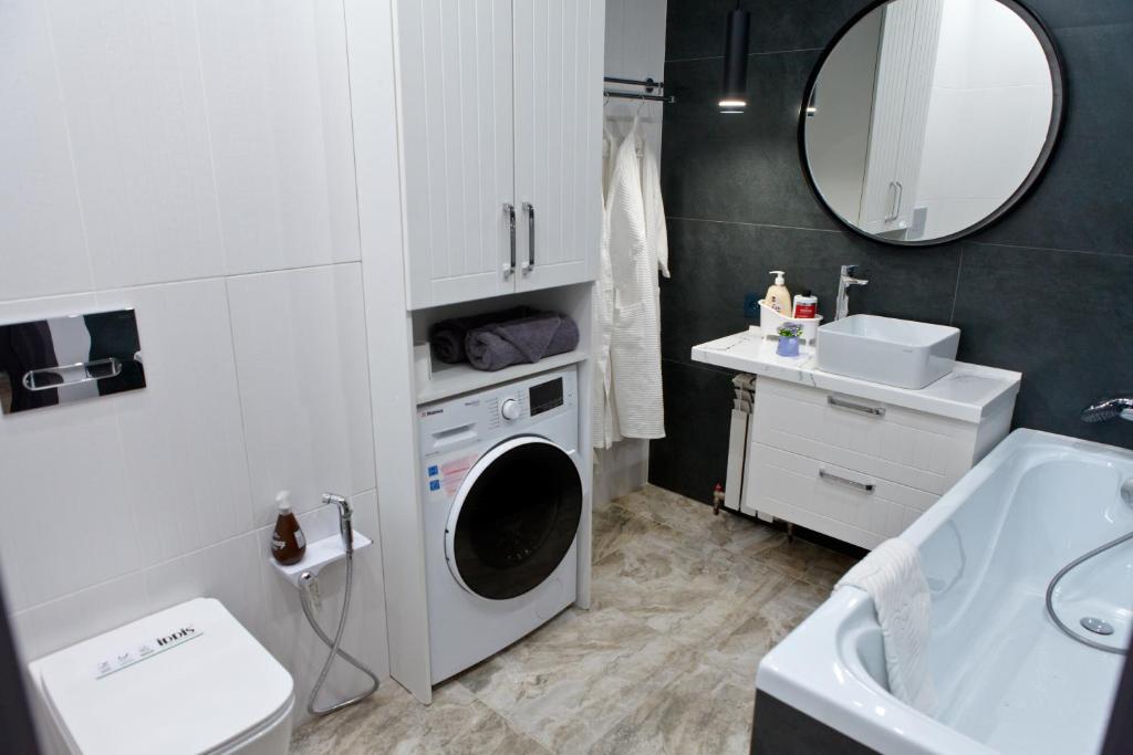 uma casa de banho com uma máquina de lavar roupa e um lavatório em Байзакова 133, новостройка em Pavlodar
