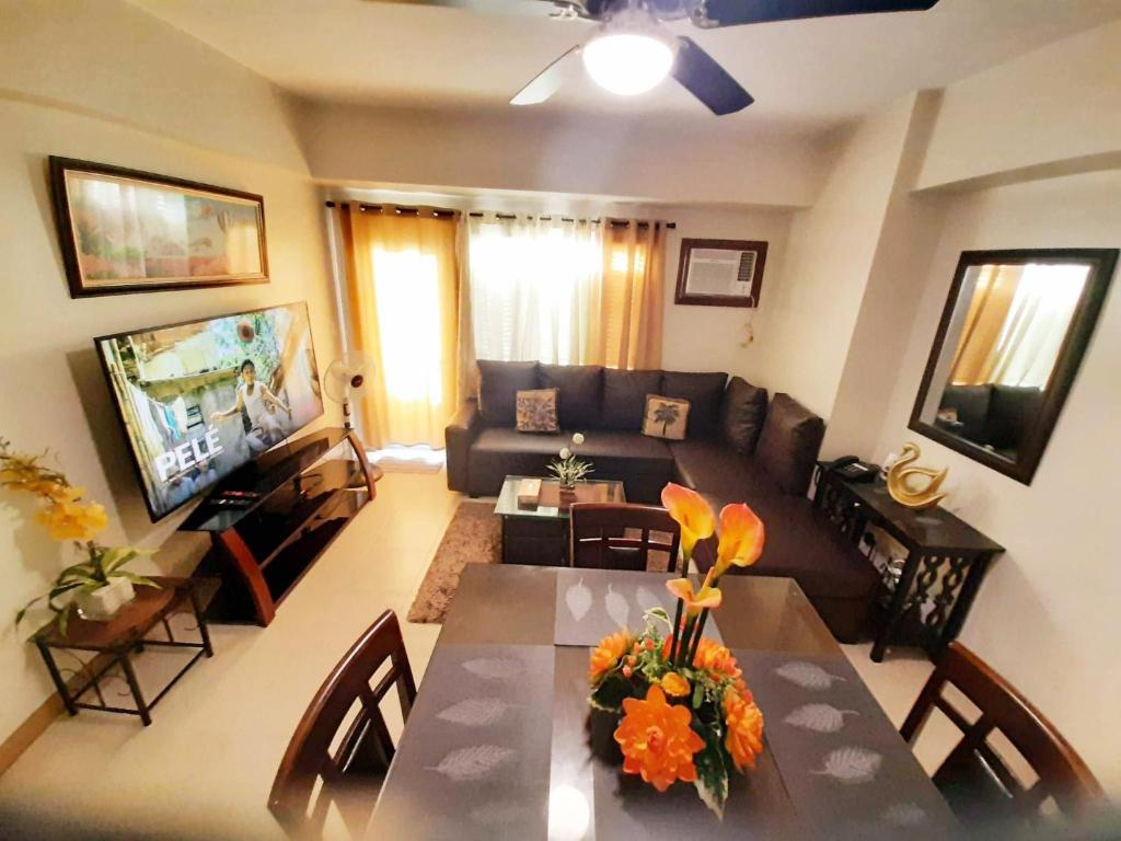 a living room with a couch and a table with flowers at Manhattan Plaza Tower 1 in Manila