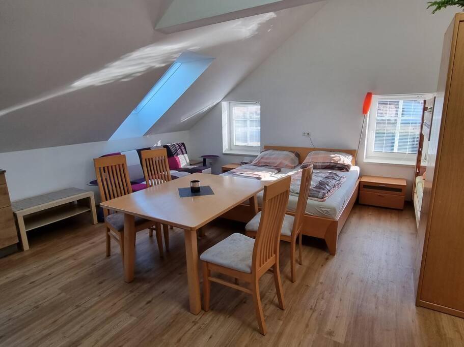 a room with a table and a bed and a bedroom at lovely apartment in Oberpilsbach