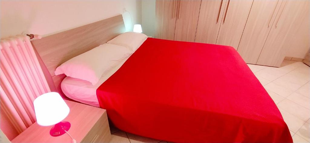 - un lit avec une couverture rouge dans l'établissement Case vacanza Erica Igea Marina, à Bellaria-Igea Marina