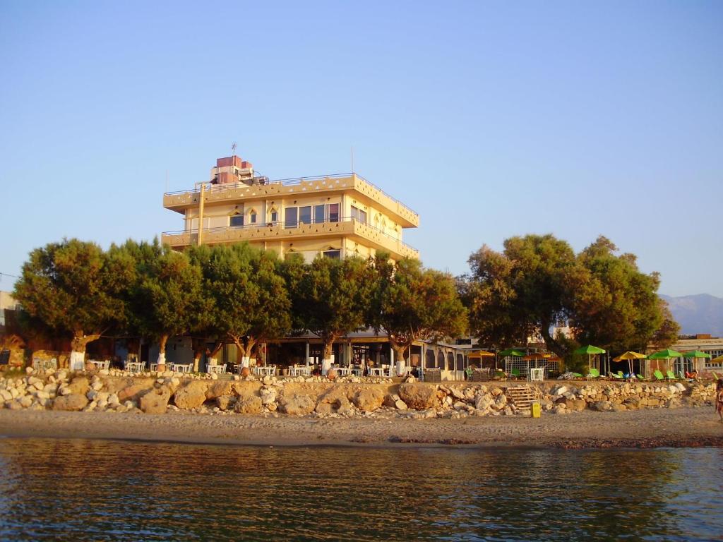 a large building on the shore of the water at Melani Apartments in Chania