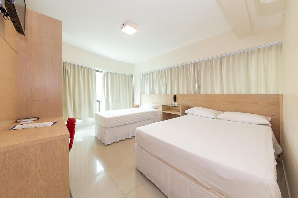 um quarto com duas camas num quarto de hotel em Slim São José Zion em São José
