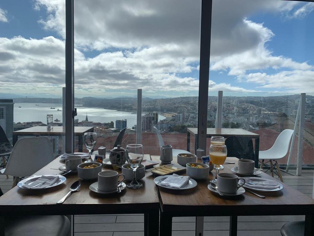 una mesa con comida y bebida y vistas a la ciudad en BO Hotel & Terraza en Valparaíso