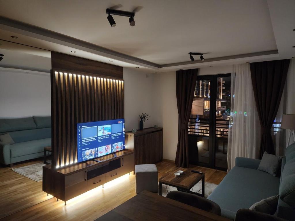 a living room with a blue couch and a television at Apartman IN Zlatibor in Zlatibor