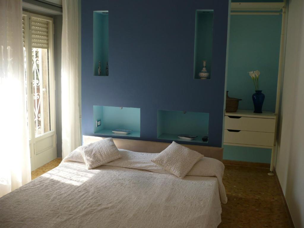 una camera blu con un letto bianco e una parete blu di Joe's Unforgettable Vatican Nest a Roma