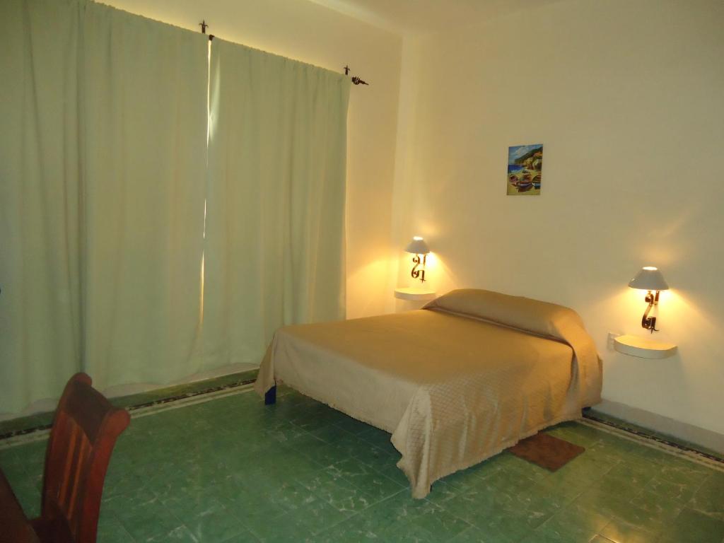 a bedroom with a bed and two tables and a window at Hotel Suites Córdoba in Córdoba