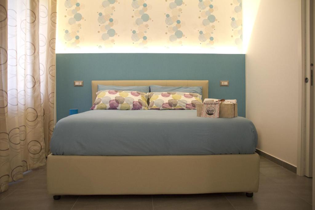 1 dormitorio con 1 cama con pared azul en Happy Home, en Fiumicino