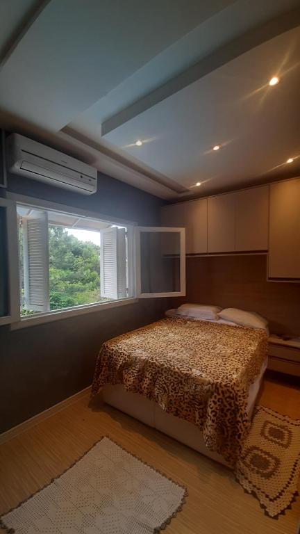 1 dormitorio con cama y ventana en Casa nos ingleses, en Florianópolis