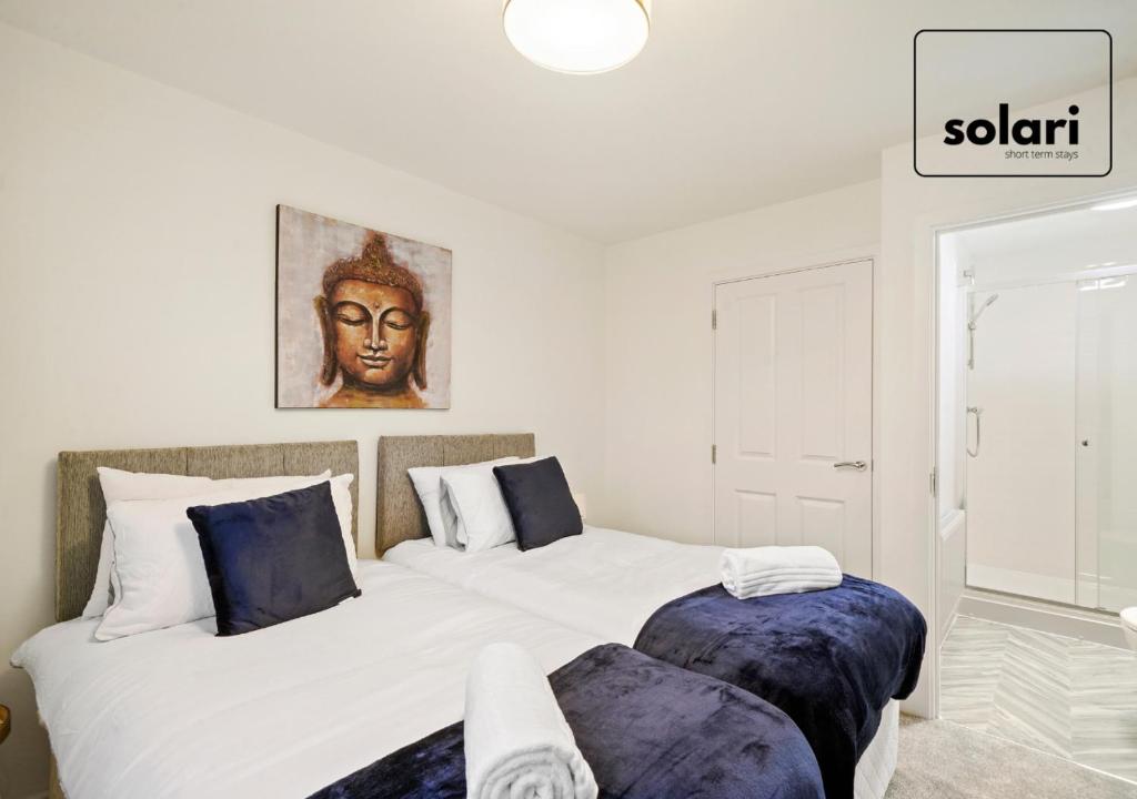 ein Schlafzimmer mit zwei Betten mit blauen Kissen in der Unterkunft Lux 4 Bed Contractor x Relocator Apartment, 30 Percent Off Monthly Stays, FREE Multiple Parking Spaces, Super Fast WiFi, Streaming Services included, Close to A1 in Peterborough
