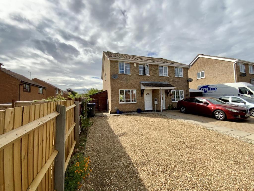 uma casa com um carro estacionado numa garagem em Welcoming House with Large Driveway, Private Garden, Fast Wifi and Smart TV by Yoko Property em Northampton