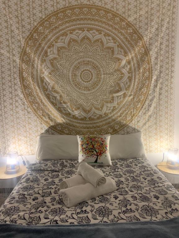 ein Bett mit einem großen Kopfteil mit zwei Handtüchern darauf in der Unterkunft Beréber أحلام in Jerez de la Frontera