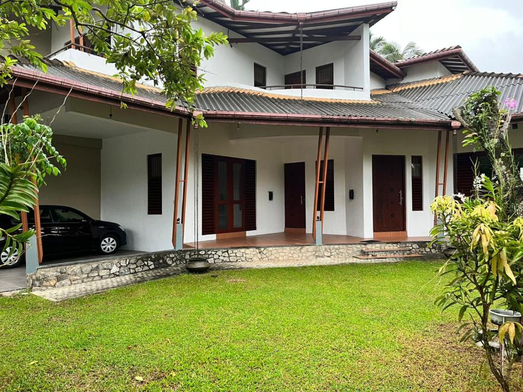 a house with a car parked in front of it at Serene Holiday Home in Pannipitiya