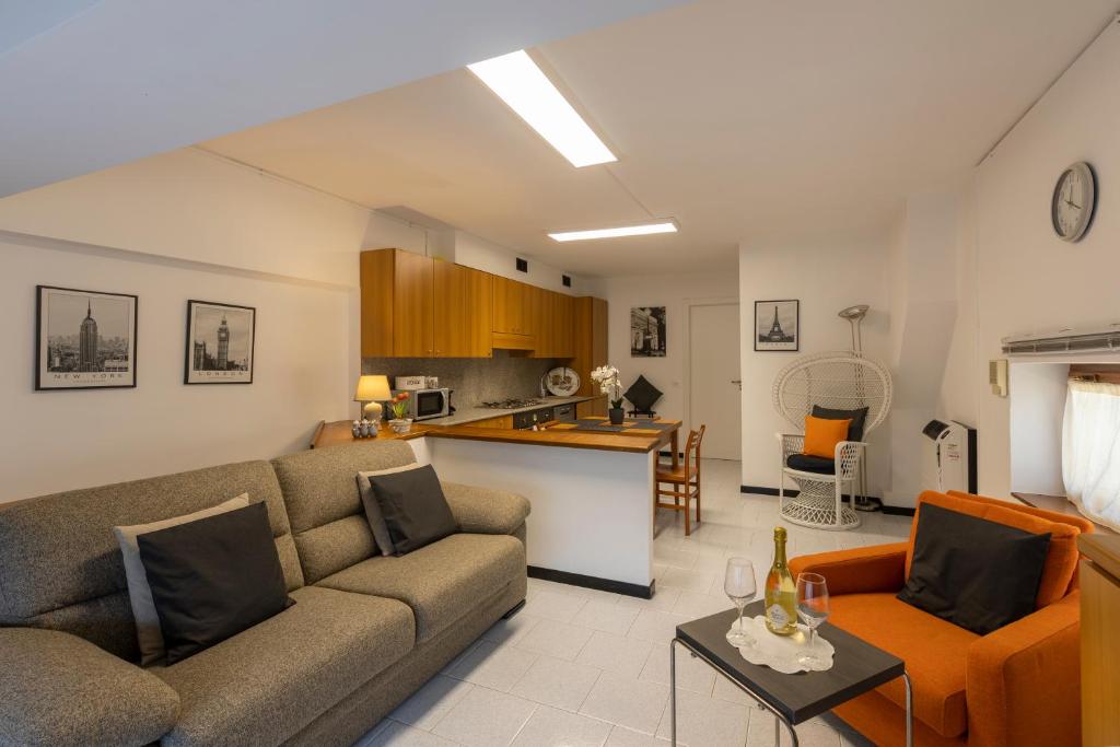 een woonkamer met een bank en een keuken bij La Perla del Lario 51 in Bellagio