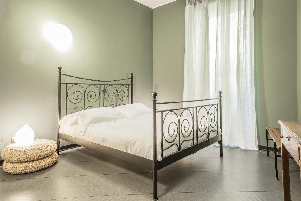 - une chambre avec un lit doté de draps blancs et une fenêtre dans l'établissement Margreth Apartment, à Milan