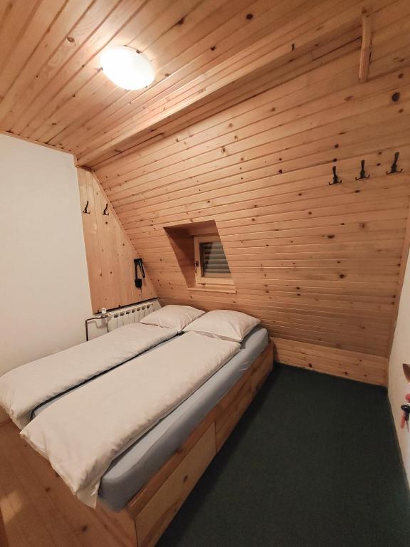 a bedroom with a bed in a wooden room at Apartments A Vlasic in Vlasic