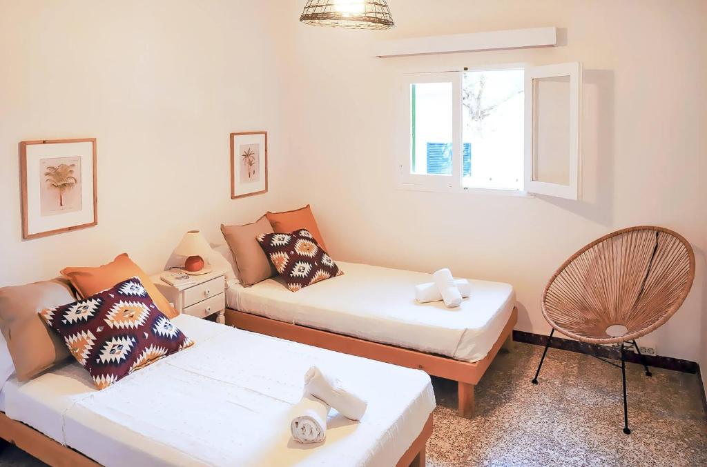 een woonkamer met 2 bedden en een bank bij Apartamento Ses Botges - Formentera Break in Es Calo