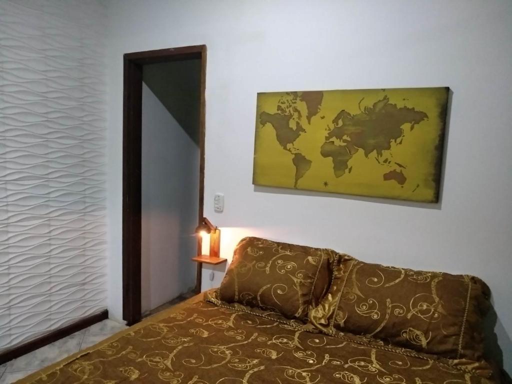 a bedroom with a bed and a map on the wall at Odoya Guest House in Salvador