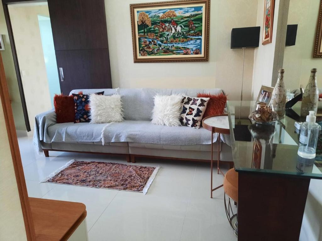 a living room with a couch and a glass table at Apto com conforto que você precisa. in Goiânia