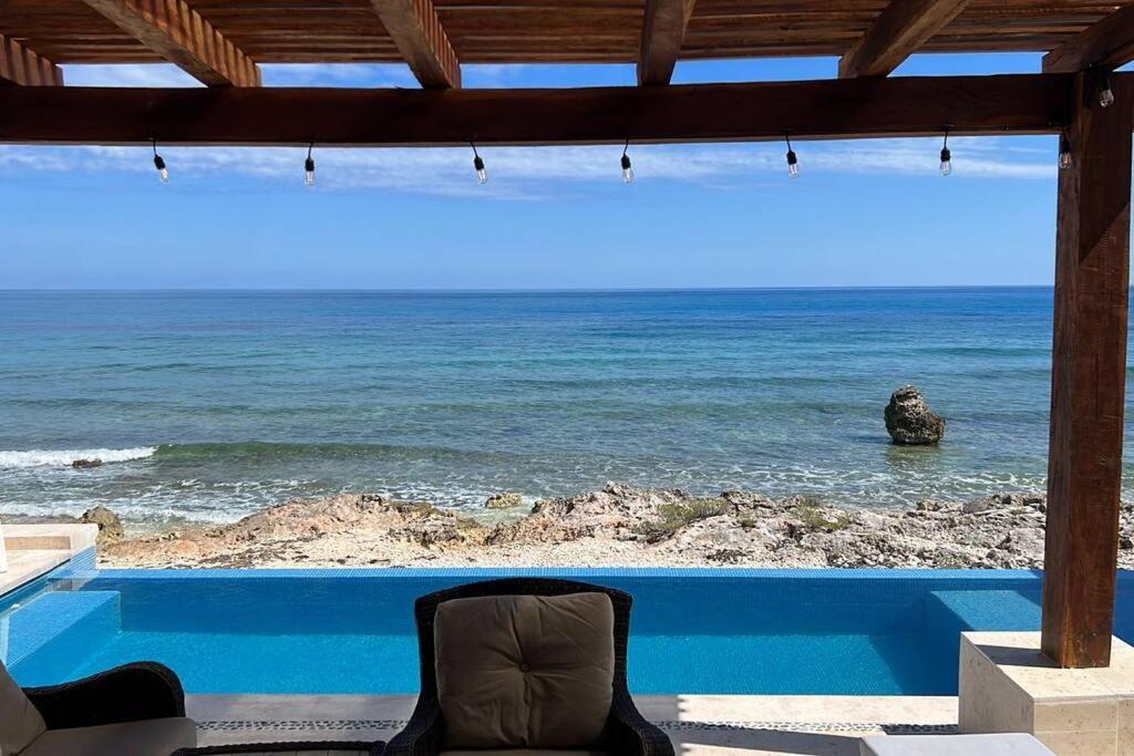 Casa Javi- Ocean Front located Mid Isla Mujeres في إيسلا موخيريس: كرسي جالس على فناء مطل على المحيط