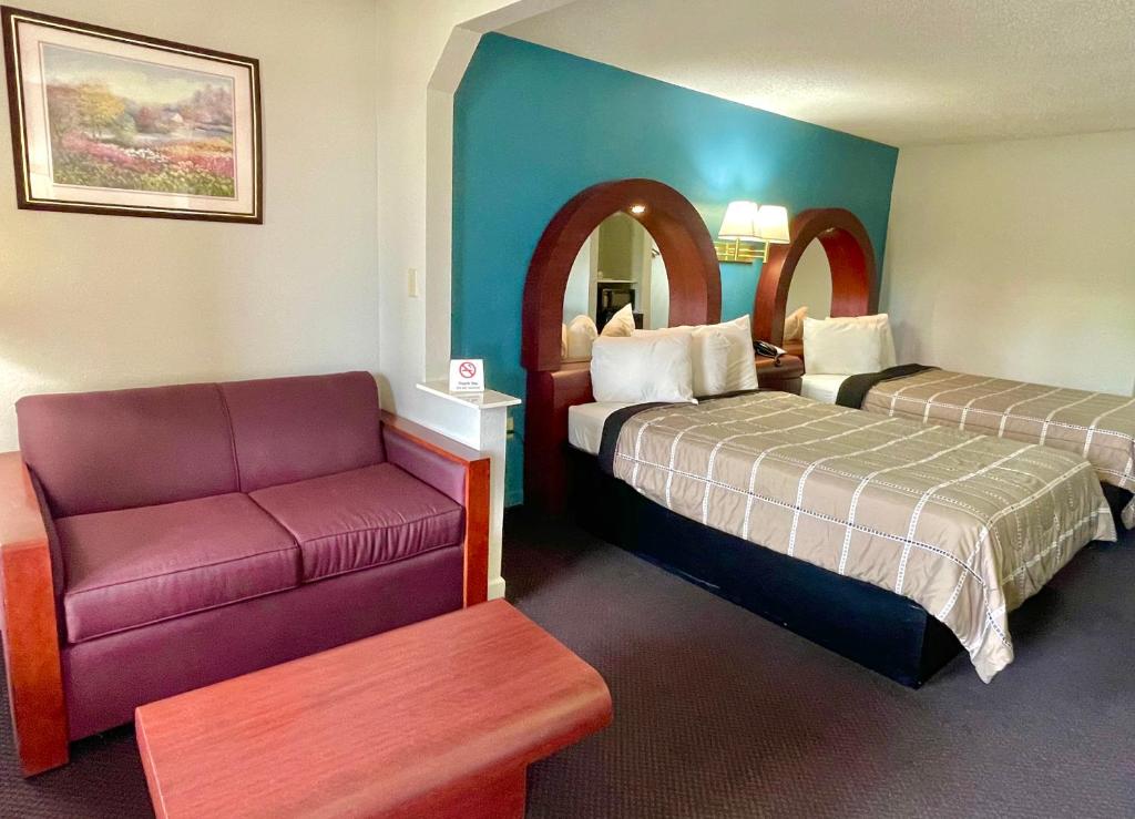 Luxury Inn & Suites في سيلما: غرفة فندقية بسريرين وكرسي