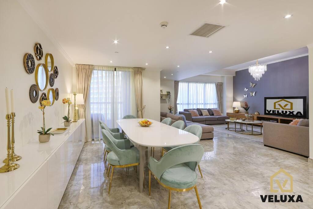 uma sala de estar com uma mesa branca e cadeiras em Veluxa - Spectacular 4 Bedroom Beach Home em Dubai