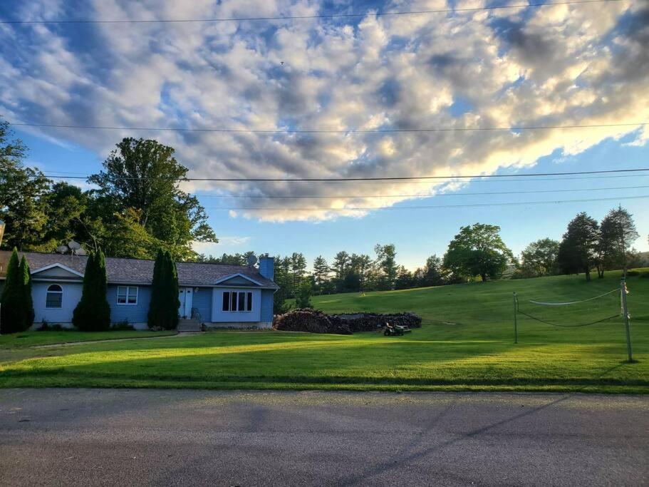 een wit huis op een grasheuvel met een huis bij Glenwood Home in Delaware Water Gap