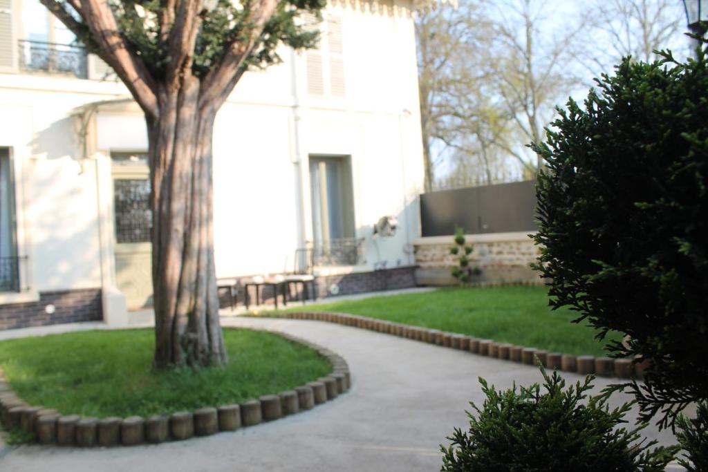 une passerelle devant un bâtiment avec un arbre dans l'établissement Belle Maison de 5 pièces (150 m²), à Sceaux