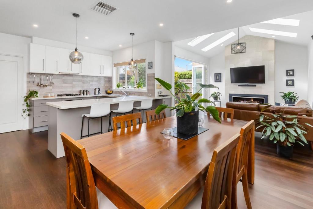 a kitchen and dining room with a wooden table and chairs at Bangalow Mornington in Mornington