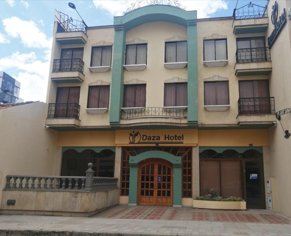 a large building with a sign for a hotel at Daza Hotel in Paipa