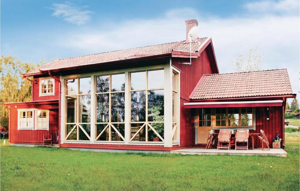 a red barn with a table and chairs in a field at Nice Home In Jrvs With Sauna in Järvsö