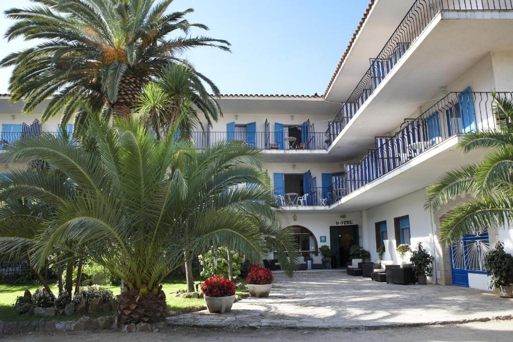 a building with palm trees in front of it at Hotel Bell Repos in Platja d'Aro