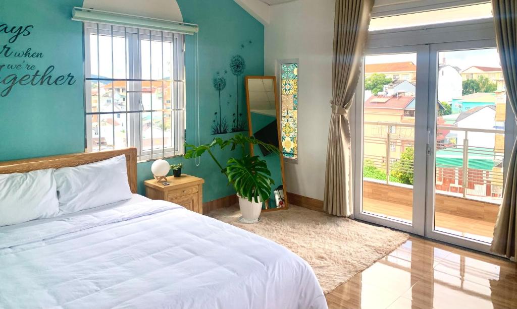sypialnia z białym łóżkiem i balkonem w obiekcie Mi Casa Homestay w mieście Da Lat