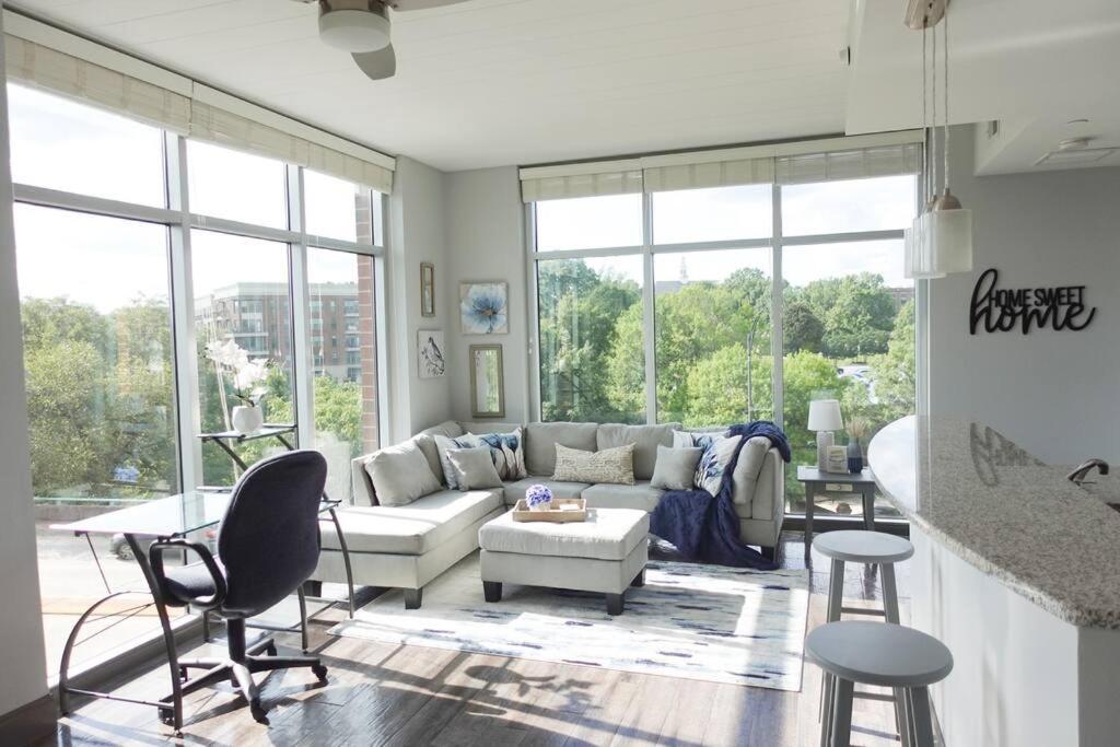 a living room with a couch and a table and chairs at Luxury Downtown Apartment with Balcony! in Greenville